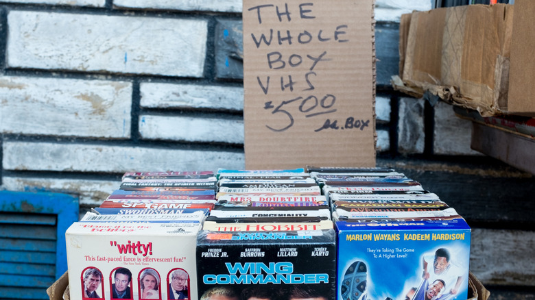 A box filled with VHS tapes for sale