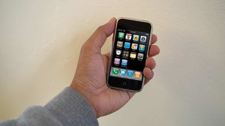 a first generation iPhone in man's hand