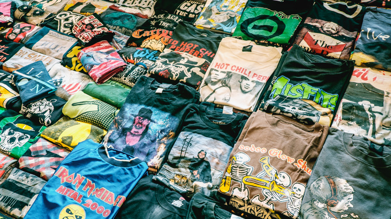 A spread of vintage t-shirts at an open-air market.