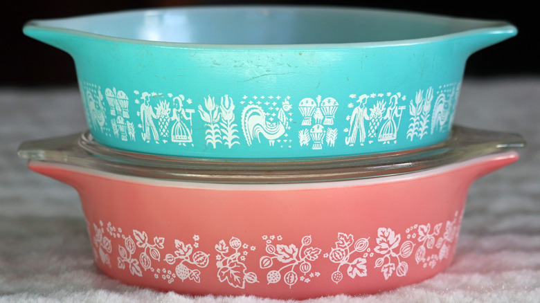 Two stacked vintage Pyrex dishes in pink and blue