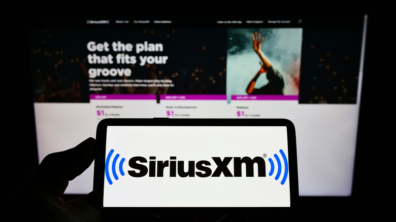 Sirius XM logo on smart phone atop company subscriber website