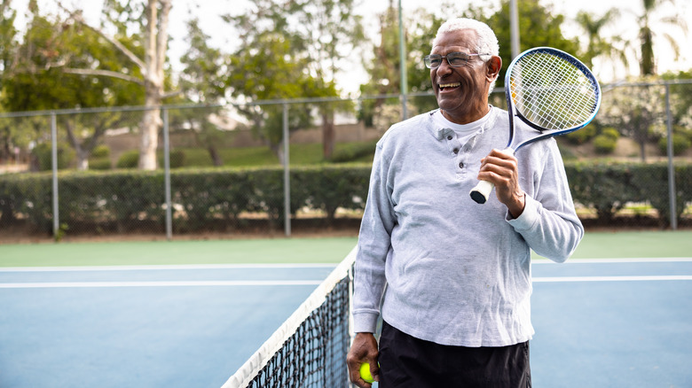 Man laughing on tennis court