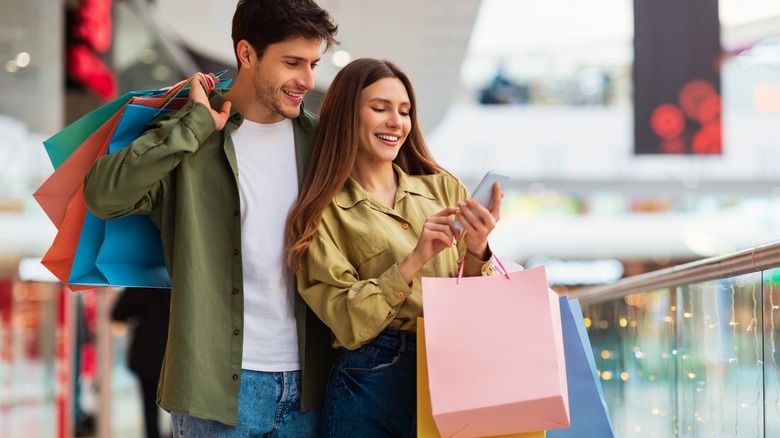 Smiling man and woman with shopping bags