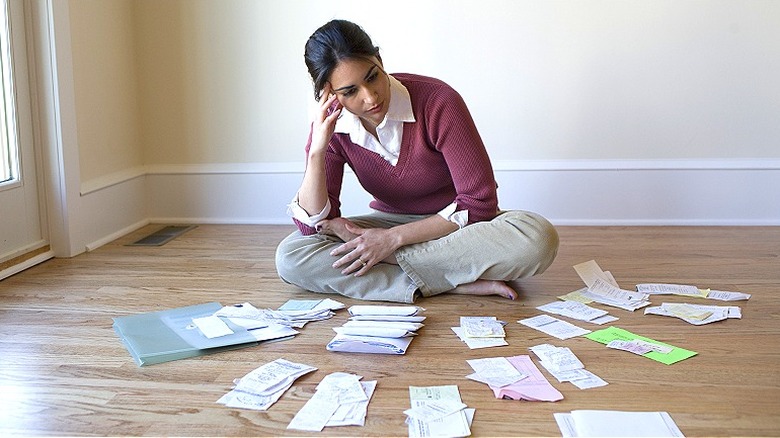 Person surrounded by bills, receipts