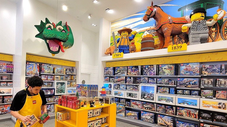 Worker stocks displays inside the New York Lego store