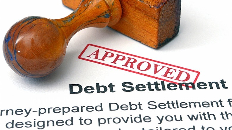 Debt settlement paperwork stamped "Approved"