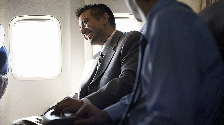 Business traveler smiling on airplane
