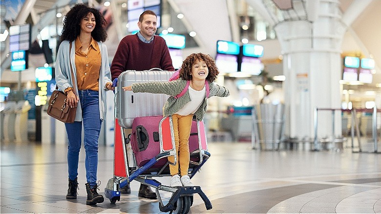 Family smiling, walking through airport