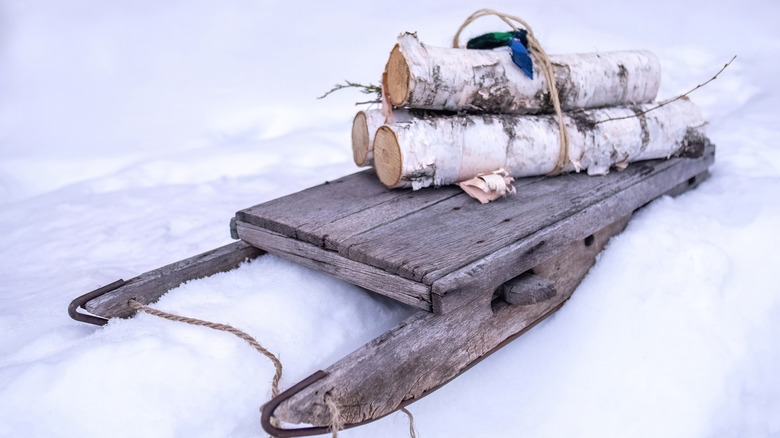 Vintage sledge or sled with a bundle of birch logs on top