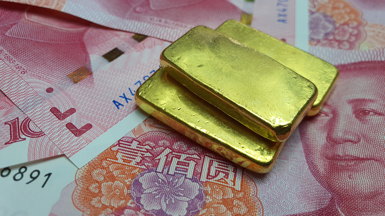 Gold bars rest atop Chinese bank notes