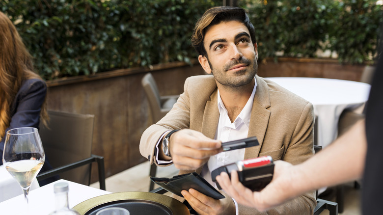 Man paying waiter with credit card