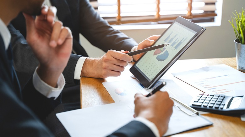 Two people looking at data on tablet screen