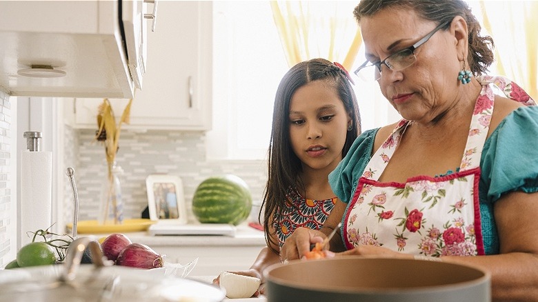 Hispanic mother and daughter cooking