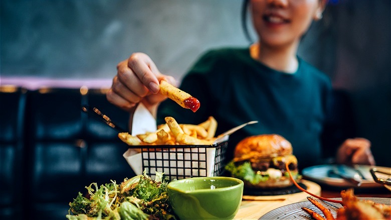 Person dipping restaurant fries