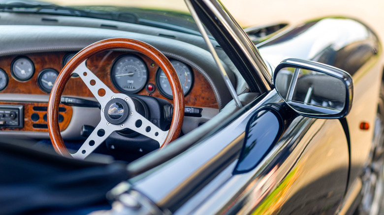 A wooden steering wheel and old-fashioned small gauges of the historic cabriolet