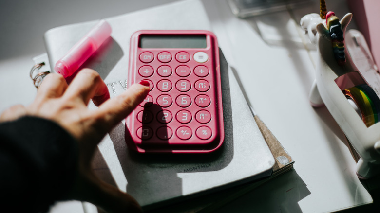 A calculator and pencil and some clips in white