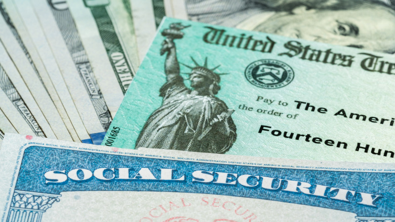 A social security card sitting on top of a U.S. Treasury check and currency.