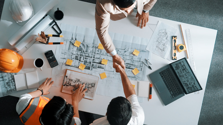 Top down aerial view of architect engineer team shake hands