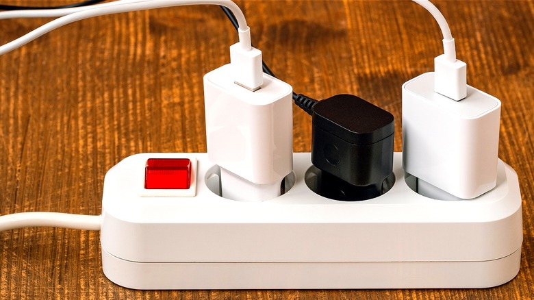 Three smartphones charging on table