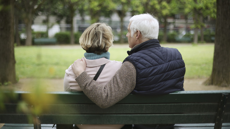 a retired couple sitting on a bench