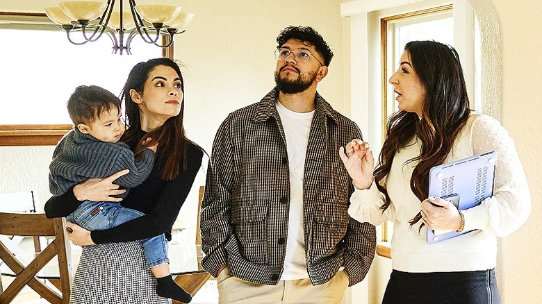 A real estate agent shows a young family a home