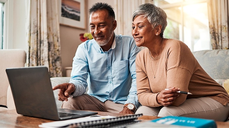 Older couple smiling at laptop