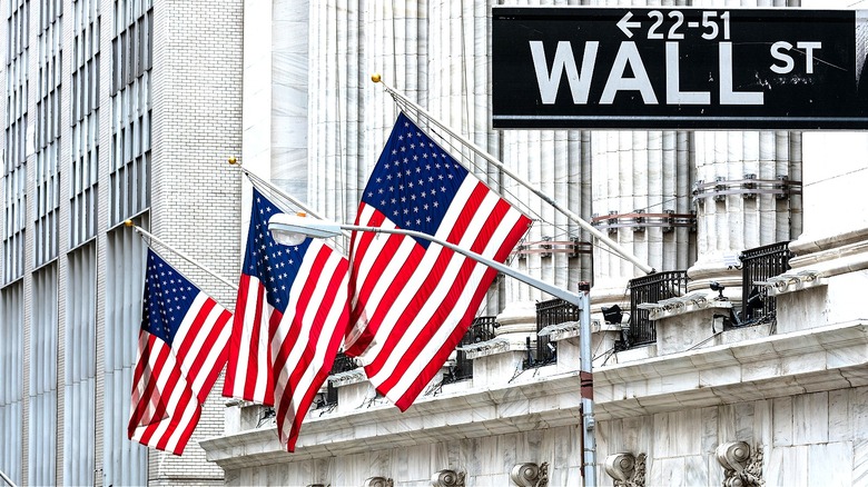 Wall Street sign seen in front of three American flags