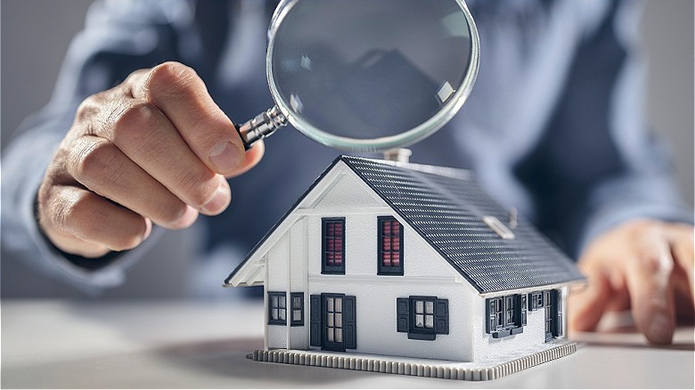 Examining house with magnifying glass