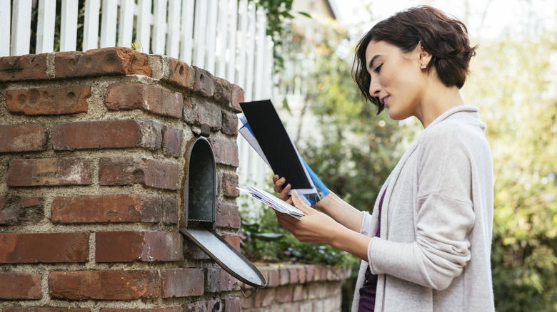 A woman checking her mail from the mail box