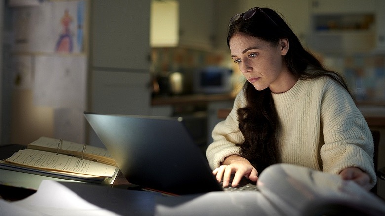 Person reading laptop at night