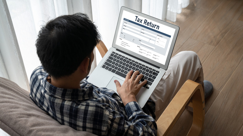 man doing taxes on laptop computer