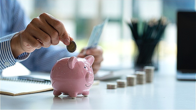 Person saving money in piggy bank