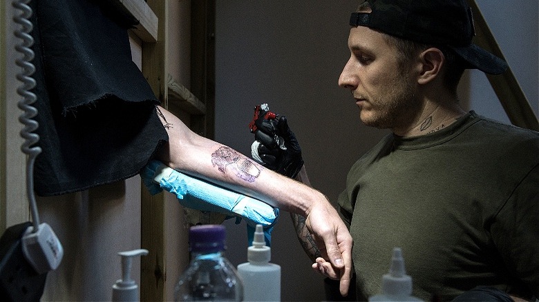 Scott Campbell tattooing an arm