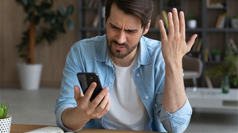 Angry man speaking on telephone