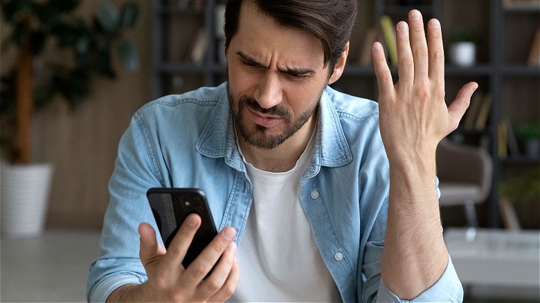 Upset person looking at smartphone