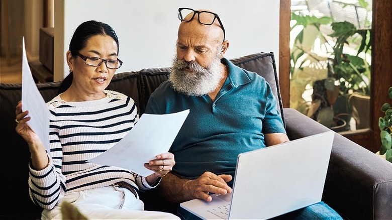 Couple on couch reviewing documents 