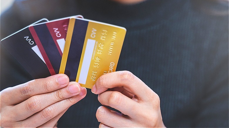 Person holding three credit cards