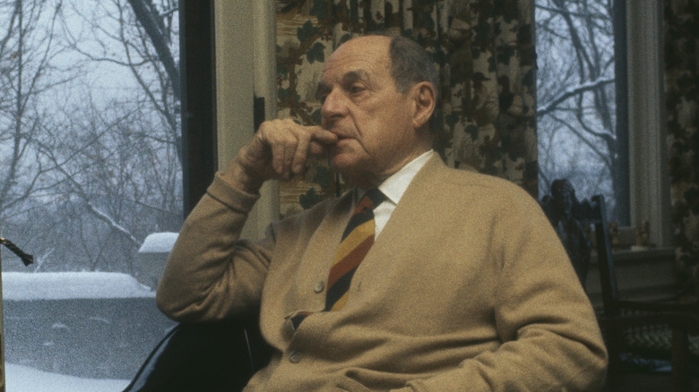 Older man looks out window at snow