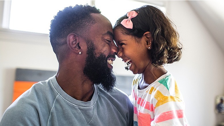 Dad with daughter laughing together at home