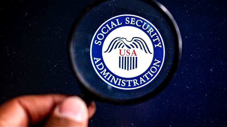 Social Security Administration logo being viewed through a magnifying glass with a black background