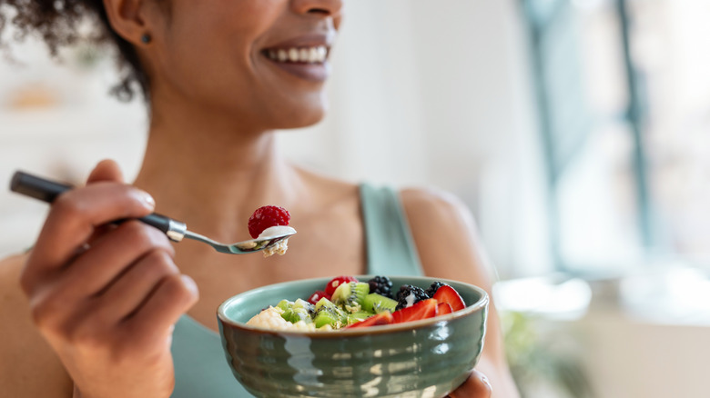 Woman eating a healthy bowl of fruits