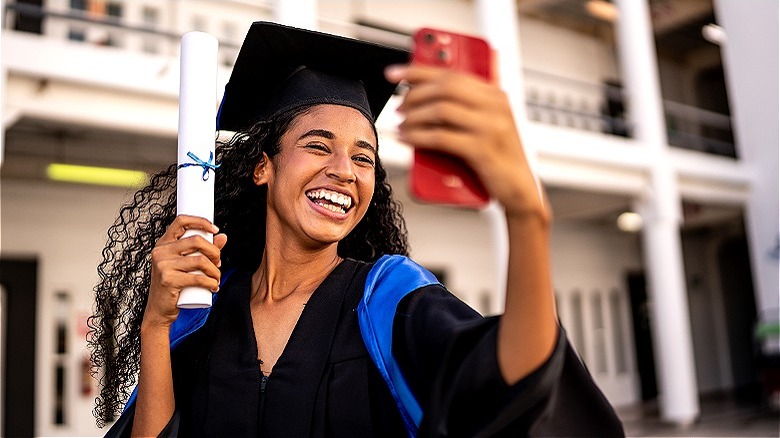 High schooler taking graduation selfie