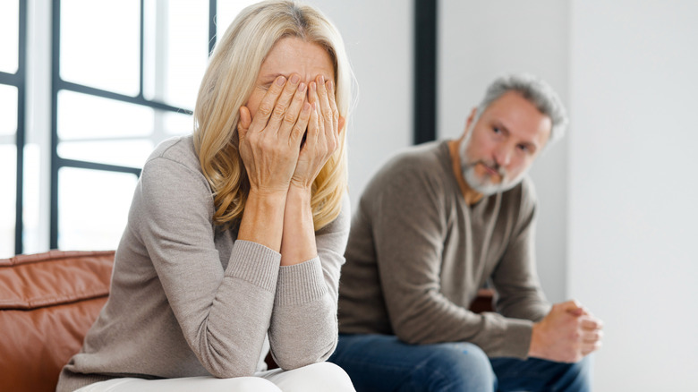 sad older couple holding head in hands