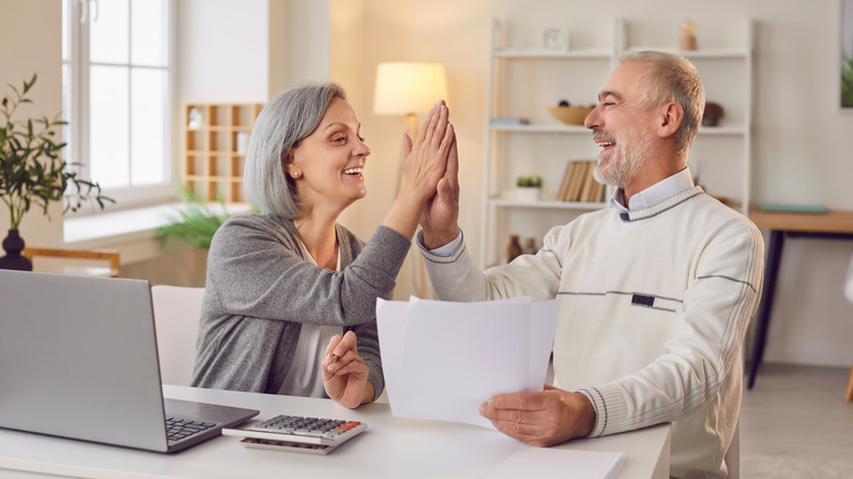 happy older couple sitting at a desk