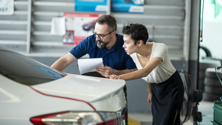 Insurance agent explaining car damage to customer