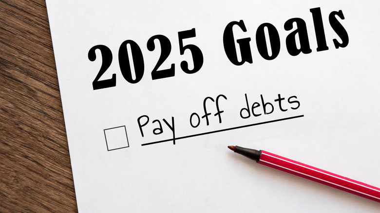 Paper and pen showing 2025 goals to pay off debts