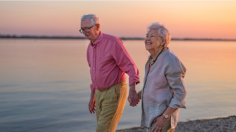 Senior couple walk on beach