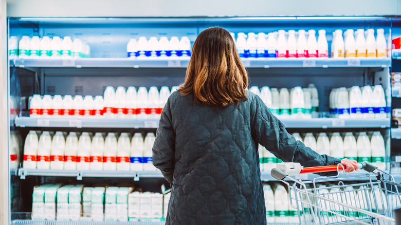 Woman shopping dairy aisle of grocery store