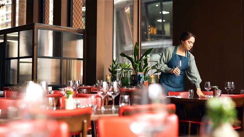 Server preparing restaurant dining room