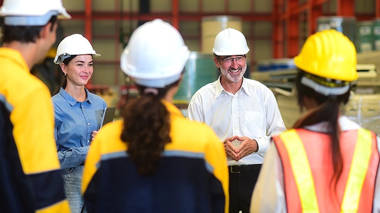 Meeting of a group of five individuals wearing hard hats